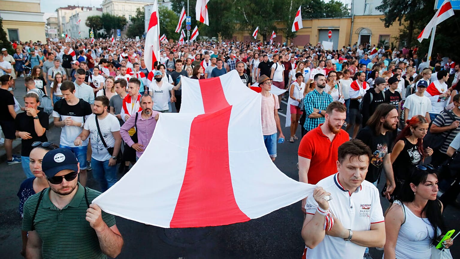 People carry an old Belarusian national flag during an opposition rally in Minsk, Belarus, Monday, Aug. 17, 2020