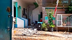 In this photo provided by the Philippine Red Cross, debris are scattered at a house after a quake struck in Cataingan, Masbate province, central Philippines.