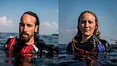 Danish activist Ida Marie and German activist Fabian swimming with Rainbow Warrior in the background.
