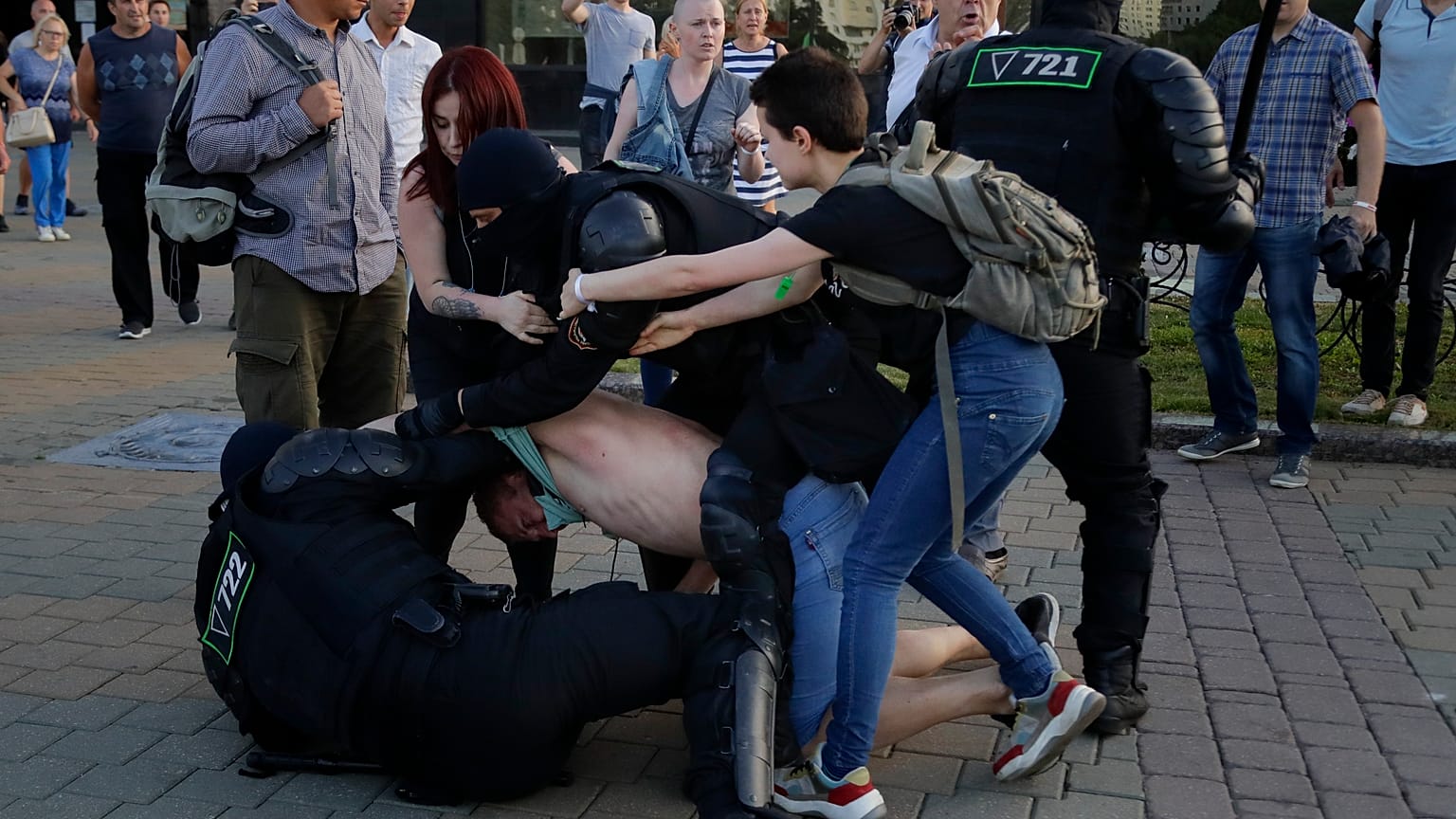 La policía detiene a un manifestante mientras dos mujeres tratan de defenderlo durante una manifestación contra las disputadas elecciones presidenciales en Minsk, Bielorrusia.