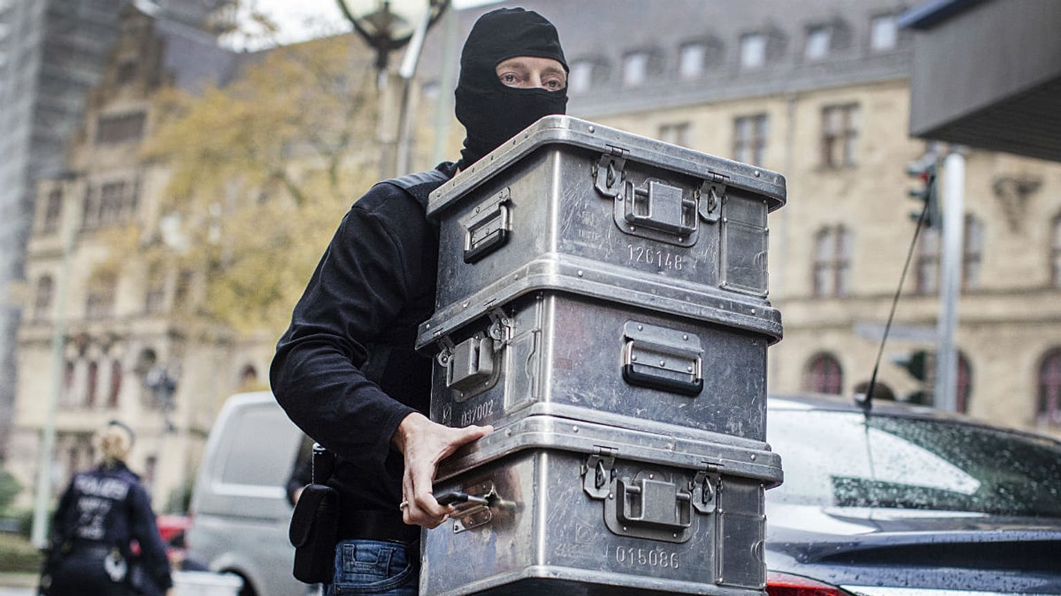 Police carry boxes after investigations at a jeweler in Duisburg-Marxloh, western Germany