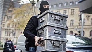 Police carry boxes after investigations at a jeweler in Duisburg-Marxloh, western Germany
