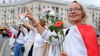 Belarusians protesting against disputed presidential elections results hold flowers and flash victory signs during a protest in Victory Square in Minsk, Belarus. August 20