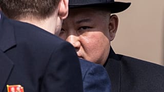 El líder norcoreano Kim Jong Un, de fondo, asiste a una ceremonia de despedida en la principal estación de tren de Vladivostok (Rusia).