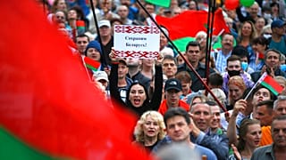"Save Belarus!" reads the poster a woman is holding among demonstrators in Minsk