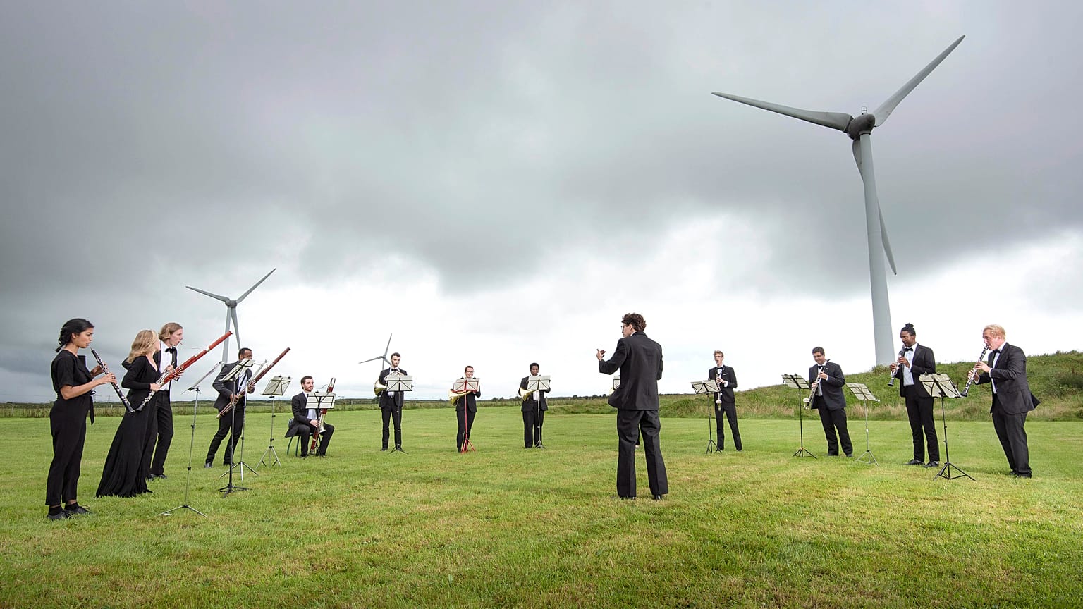 Orchestra for the Earth performs under wind turbines in Delabole, UK. 