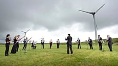Orchestra for the Earth performs under wind turbines in Delabole, UK. 