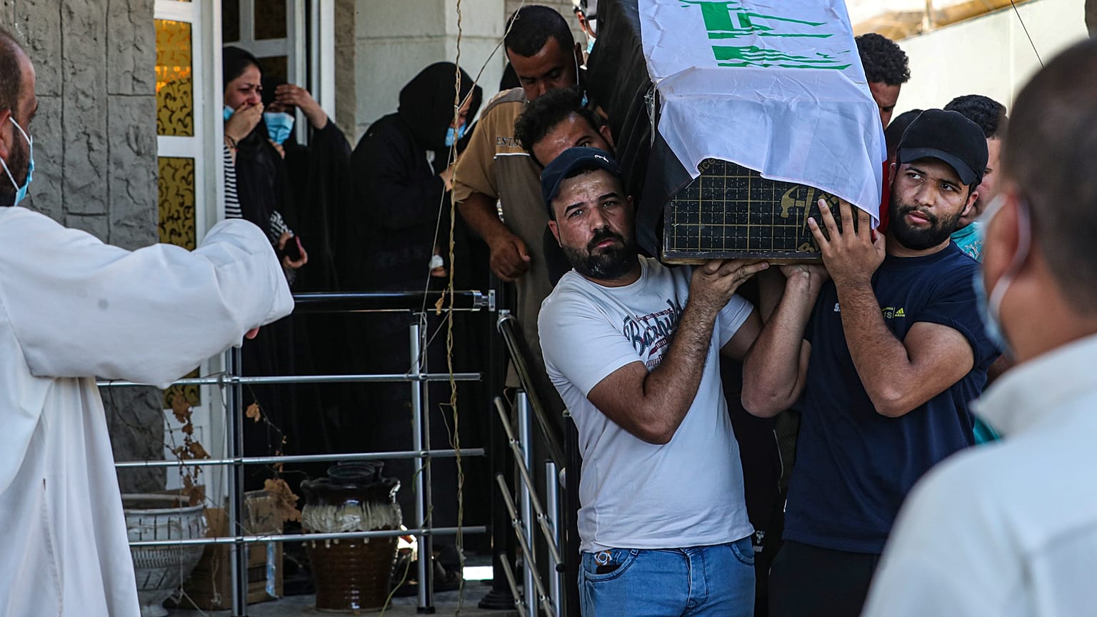 مشيعون يحملون نعش ريهام يعقوب المغطى بالعلم خلال جنازتها في البصرة، العراق