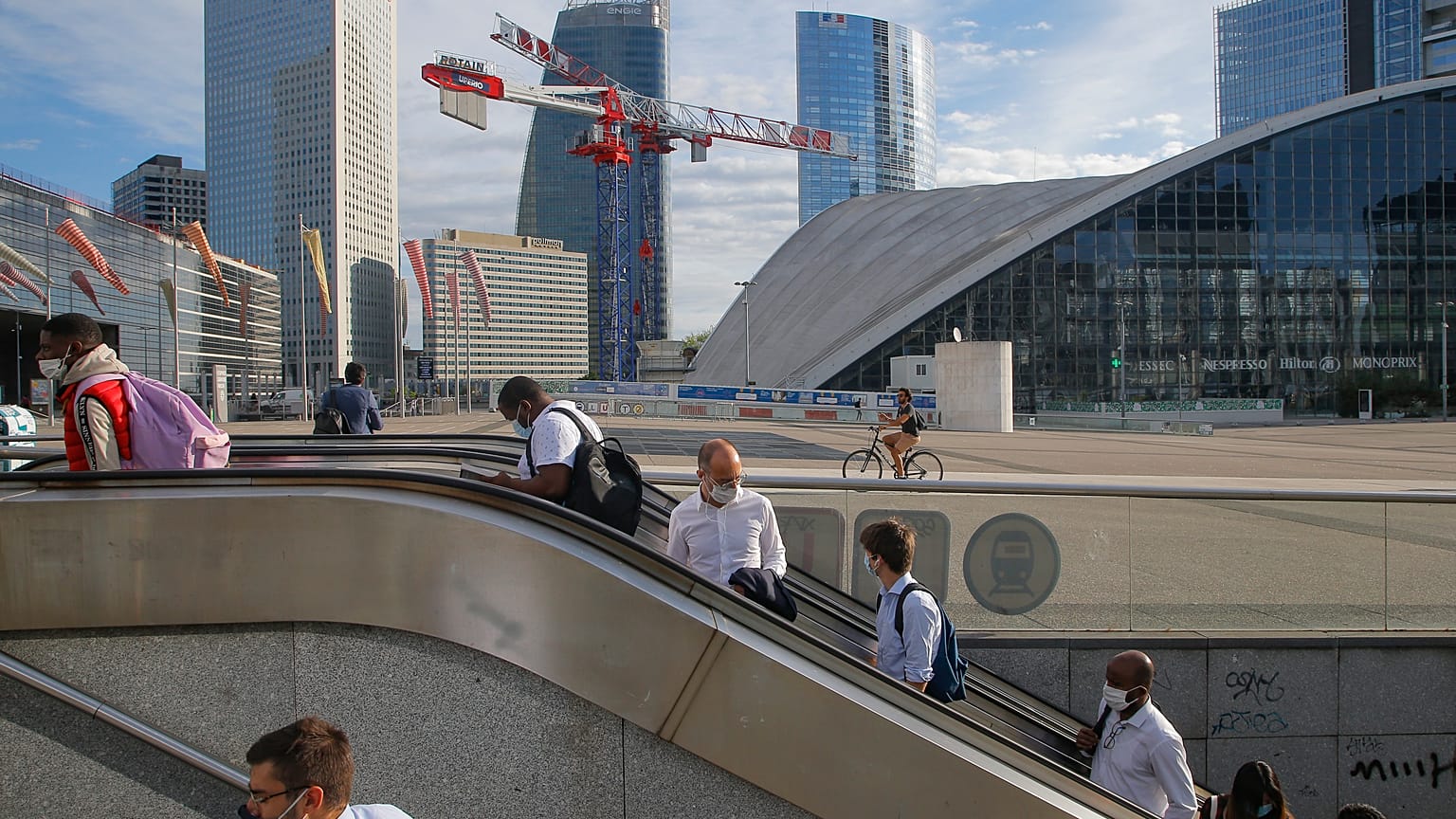 Usarios del metro salen de la estación con las mascarillas puestas en el barrio parisino de "La Defense"