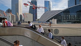 Usarios del metro salen de la estación con las mascarillas puestas en el barrio parisino de "La Defense"