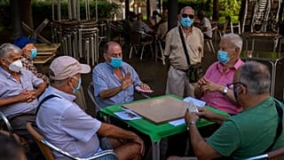 متقاعدون يرتدون كمامات ويلعبون الورق في حديقة في جزيرة جران كناريا في إسبانيا