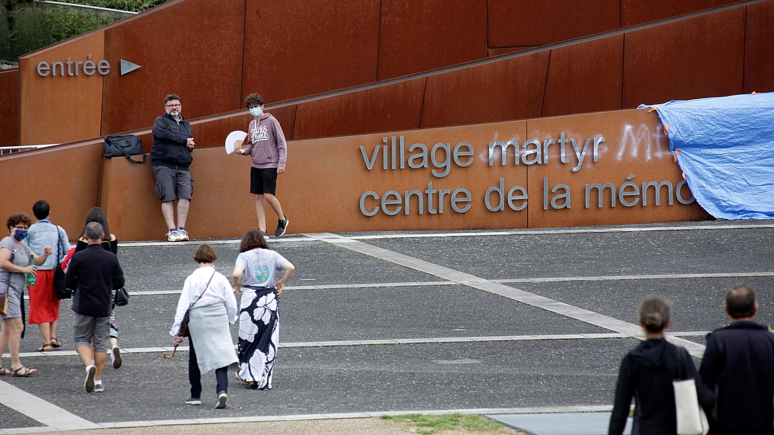 Graffiti tags are seen on the lettering at the entrance to the Centre of Oradour sur Glane Memory.