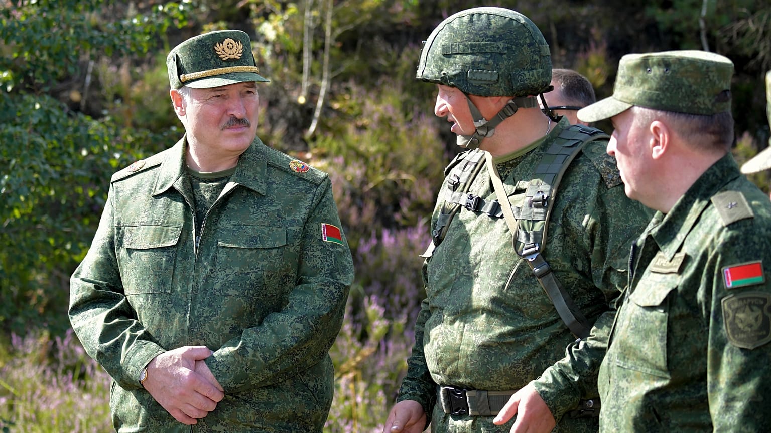 Belarusian President Alexander Lukashenko, left, speaks to high rank officers as he visits a military exercise near Grodno, Belarus.