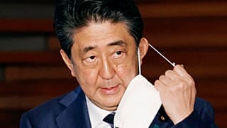 In this May 21, 2020, file photo, Japan's Prime Minister Shinzo Abe removes a face mask as he speaks at a press conference in Tokyo. 
