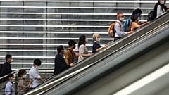 People wearing face masks to help protect against the spread of the coronavirus ride an escalator as they arrive at the Seoul Railway Station in Seoul