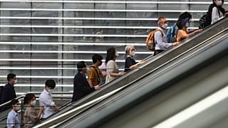 People wearing face masks to help protect against the spread of the coronavirus ride an escalator as they arrive at the Seoul Railway Station in Seoul