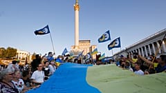 People carry a huge 33 meter-long Ukrainian national flag as they mark the State Flag Day in Kyiv, Ukraine, Sunday, Aug. 23, 2020.