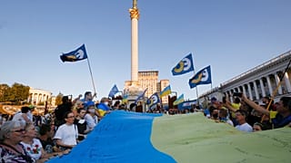 People carry a huge 33 meter-long Ukrainian national flag as they mark the State Flag Day in Kyiv, Ukraine, Sunday, Aug. 23, 2020.