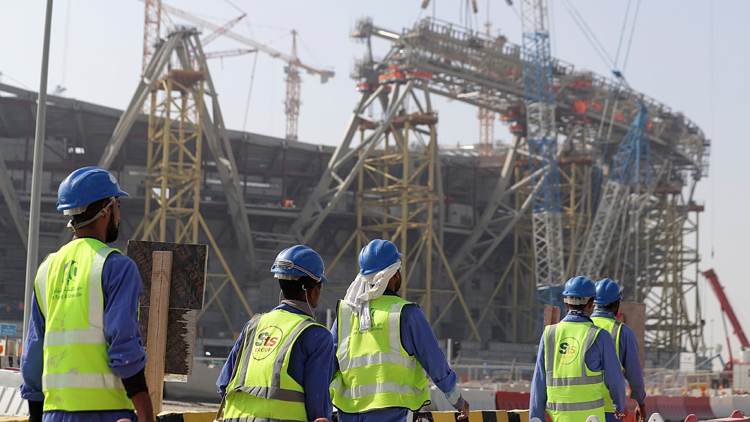Trabajadores caminan hacia el Estadio Lusail, uno de los estadios de la Copa del Mundo de 2022, en Lusail, Catar, el viernes 20 de diciembre de 2019. 