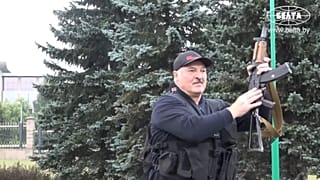 Belarus President Alexander Lukashenko armed with a Kalashnikov-type rifle greeting a riot police officer near the Palace of Independence in Minsk, Belarus