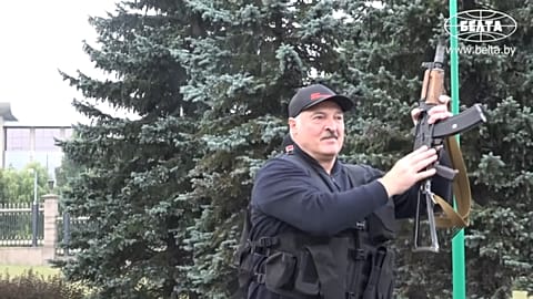 Belarus President Alexander Lukashenko armed with a Kalashnikov-type rifle greeting a riot police officer near the Palace of Independence in Minsk, Belarus