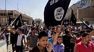 أشخاص يحملون علم داعش في الموصل عام 2006