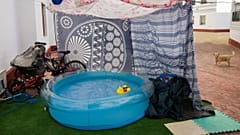 A rubber duck floats in a portable plastic pool that sits in the community housing association patio in Seville, Spain