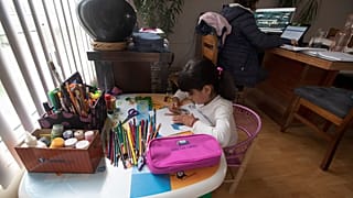 Una niña mexicana hace sus deberes en casa tras atender un curso online.