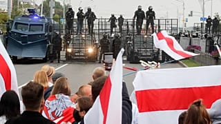 Belorusz tüntetők állnak egy rohamrendőri útlezárással előtt Minszkben 2020. augusztus 23-án
