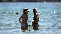 Beachgoers enjoy a hot day in the sun at a beach in Bormes-les-Mimosas, southern France, Tuesday, Aug 11, 2020