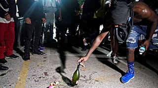 Un manifestant place une bouteille à l'endroit où un homme a été tué par balle mardi soir, lors de manifestations, à Kenosha, États-Unis, le 26 août 2020