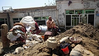 شهروند ولایت پروان روی ویرانههای منزل مسکونیاش پس از جاری شدن سیل