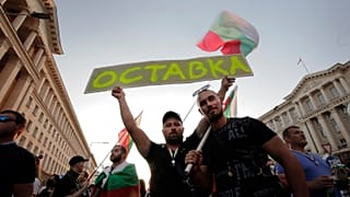 Protesters carry a poster reading "Resignation" during a mass protest in the capital, Sofia.