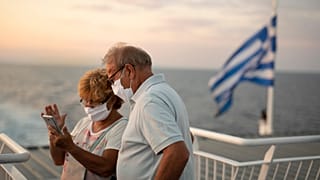 Ένα ζευγάρι φοράει μάσκες και ταξιδεύει με πλοίο