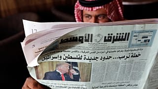 رجل يحمل صحيفة الشرق الأوسط  بمقهى في جدة -المملكة العربية السعودية.