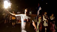 An opposition supporter lights torch during church-led protest in Podgorica, Montenegro, Thursday, Aug. 27, 2020. 