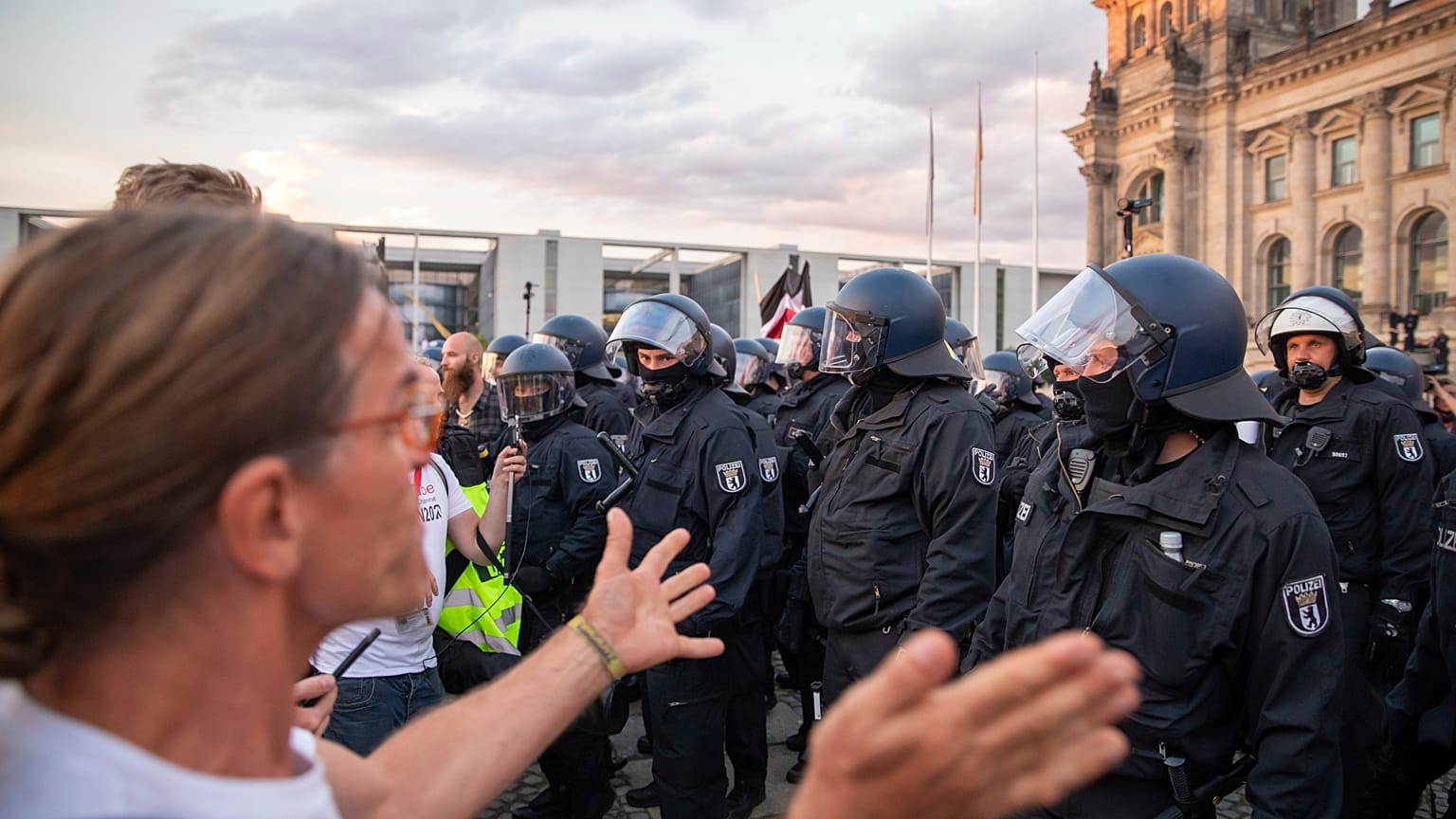 Police officers push away a crowd of demonstrators from the square 'Platz der Republik' in front of the Reichstag building. 
