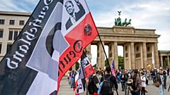 Q für QAnon und ein Portrait von Trump auf rechtsextremer Fahne
