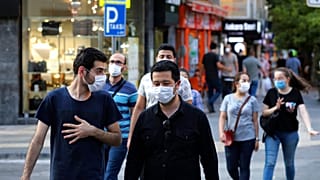 People wearing face masks to protect against the spread of coronavirus, walk in Ankara