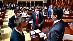 Zoran Zaev, the leader of the social democrats (SDSM), center, talks to the country's President Stevo Pendarovski, right, in parliament on Tuesday, Aug. 4, 2020 