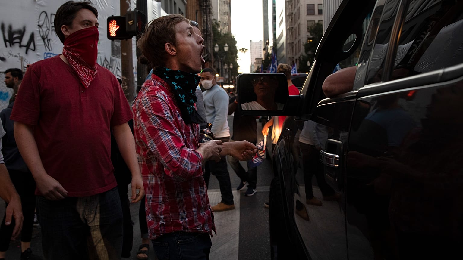 A Black L:ives Matter protester yells at a supporter of President Donald Trump during a rally and car parade.