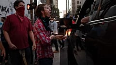 A Black L:ives Matter protester yells at a supporter of President Donald Trump during a rally and car parade.