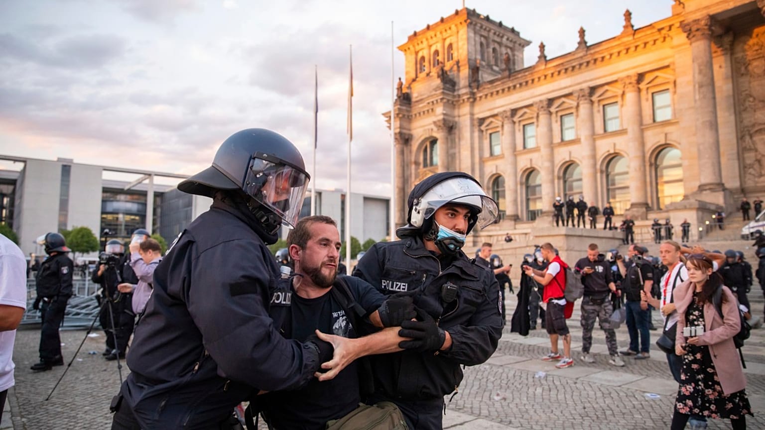 Agentes de policía alejan a una multitud de manifestantes de la plaza 'Platz der Republik' frente al edificio del Reichstag durante una manifestación, el sábado 29 de agosto. 