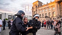 Agentes de policía alejan a una multitud de manifestantes de la plaza 'Platz der Republik' frente al edificio del Reichstag durante una manifestación, el sábado 29 de agosto. 