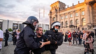Agentes de policía alejan a una multitud de manifestantes de la plaza 'Platz der Republik' frente al edificio del Reichstag durante una manifestación, el sábado 29 de agosto.
