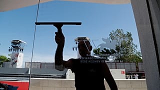A worker cleans a glass door of the Cinema Palace at the Venice Lido, Sunday, Aug. 30, 2020.