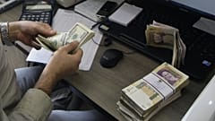 A currency exchange bureau worker counts US dollars,Tehran, Iran