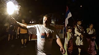 Un partidario de la oposición enciende una antorcha durante una protesta encabezada por la iglesia en Podgorica, Montenegro, el jueves 27 de agosto de 2020. 