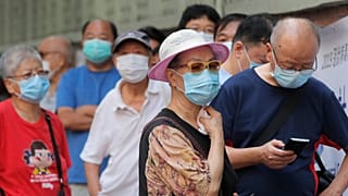 People wearing face masks queue for the coronavirus test outside a testing center in Hong Kong, Tuesday, Sept. 1, 2020.