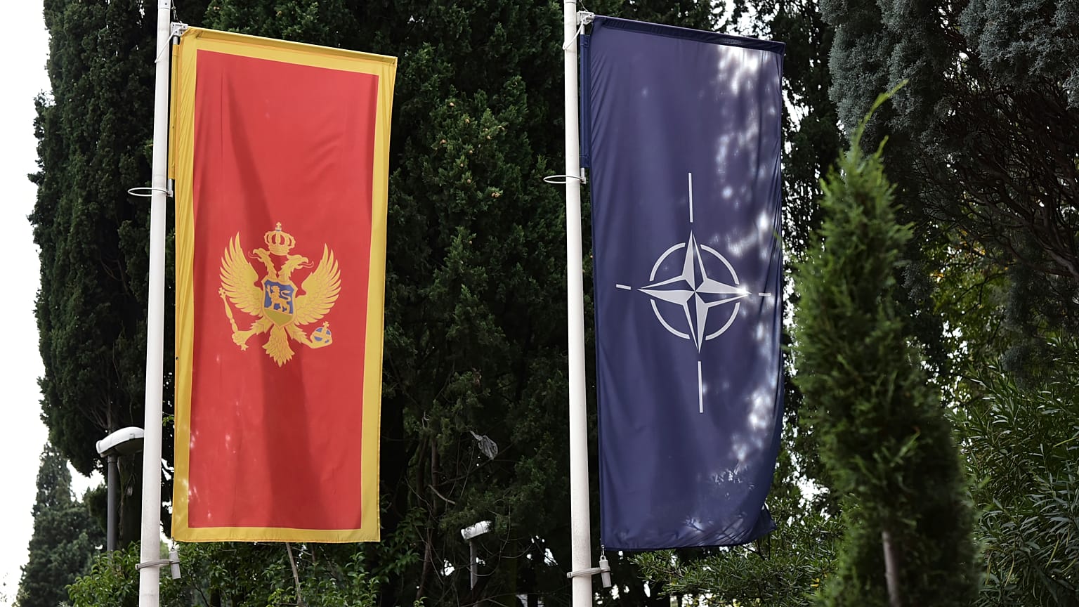 In this photo taken Monday, Nov. 11, 2019, the Montenegro, left, and NATO flags wave in front of the Montenegrin Defense Ministry in Podgorica, Montenegro.